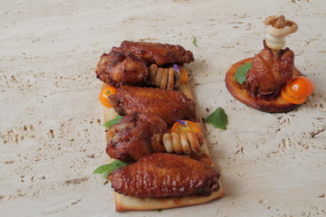  delicious fried wings with spices and herbs are aesthetically served on a marble table.