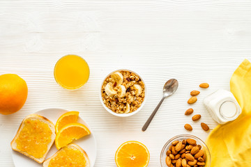 Homemade granola for morning meal. White desk with taost and fruits top-down frame copy space