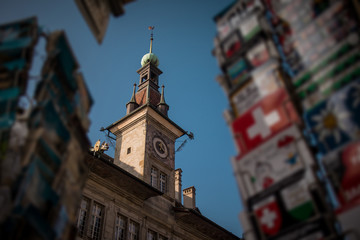 Fototapeta premium Detail of Lausanne City hall clock tower in early afternoon, looking through the swiss vintage postcards in the foreground.