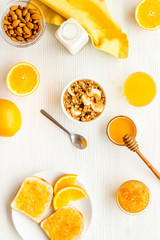 Granola for healthy breakfast. Still life composition with fruits and toast on white background top-down