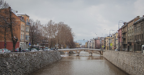 River through the centre of Sarajevo, Bosnia on a cold cloudy winter day. Visible the bridge and...