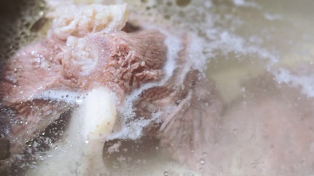 traditional beef broth, bones and ingredients in pot, cooking recipe. Soup in a cooking pot close-up macro, selective focus
