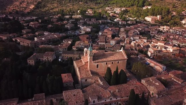 Aerial shot of Valldemossa curch and cityscape, Mallorca, Spain, surrounded by mountains