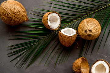 Coconuts and leaves - tropical still life on grey background top-down
