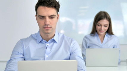 Young Businessman Working on Laptop in Office