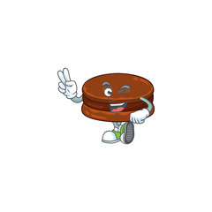A joyful chocolate alfajor mascot design showing his two fingers