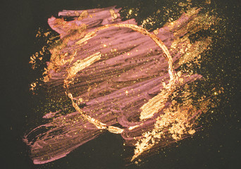 Glitter auf abstrakten goldenen und rosa Aquarellflecken, glänzender runder Rahmen auf schwarzem Hintergrund © mila_1989