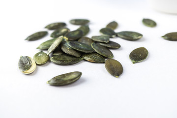 Pumpkin seeds on white background with copy space