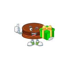 Cheerful chocolate alfajor cartoon character holding a gift box