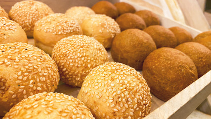 Round buns with sesame seeds. Hamburger buns made from rye flour.