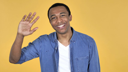 Young African Man Inviting Customers with Both Hands Isolated on Yellow Background