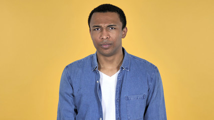 Young African Man Shaking Head to Reject Isolated on Yellow Background