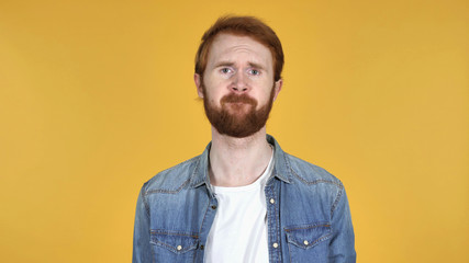 Obraz premium Redhead Man Shaking Head to Reject Isolated on Yellow Background