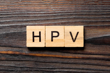 HPV word written on wood block. HPV text on wooden table for your desing, Top view concept