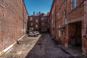 The courtyard of an old brick apartment building abandoned since Great Patriotic War (1941-1945) (World War II). Inscription in Russian: 