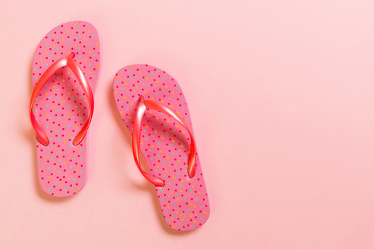Coral flip flops on pink Background. Top view with copy space