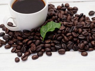 Roasted coffee beans with coffee leaves.