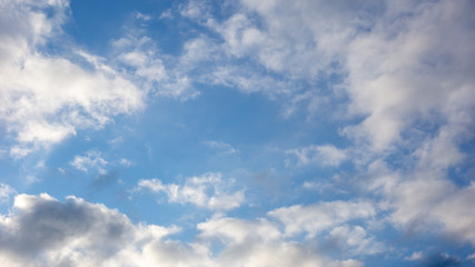 Blue sky background with white and gray clouds. Wide 16:9