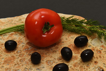 olives are scattered over pita bread with dill and tomato
