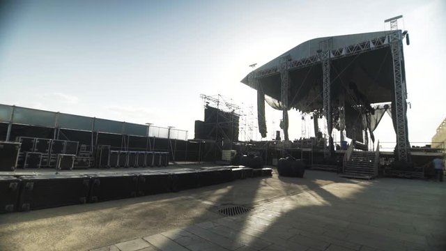 day shot of  side view of the music stage construction , big metallic music stage at a concert. flight case above , sunny day music fun active lifestyle