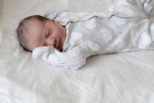 A Newborn Baby Lies On His Back With His Eyes Closed And Covers His Right Eye With His Hand In The First Minutes Of Life. A Newborn With Traces Of Primordial Lubrication Is Sleeping.