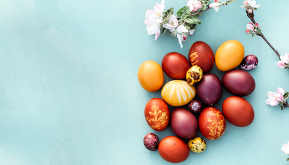 Easter background, multi-colored chicken and quail eggs on bright blue background.
