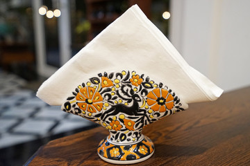 Close up colorful ceramic tissue napkin paper stand on wooden table