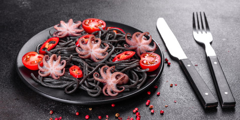Black seafood pasta with shrimp, octopus and mussels on black background. Mediterranean gourmet food