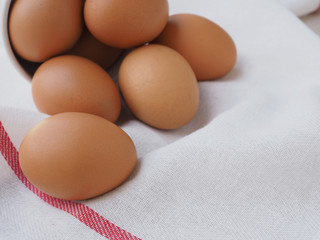  Fresh chicken eggs in a white bucket  on a white dishcloth with red straight stripes. High protein and Vitamin foods. Concept of healthy.