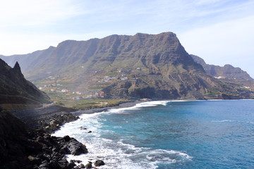 view to the village Hermigua on the Canary island La Gomera with multi colored houses and palm trees