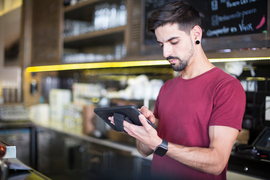 Waiter checking the orders in a pda.