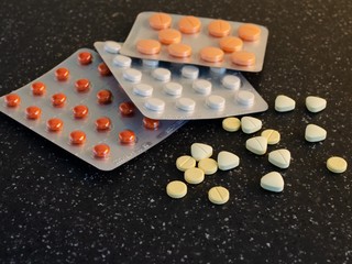 Pills in blister packs textured background, close up