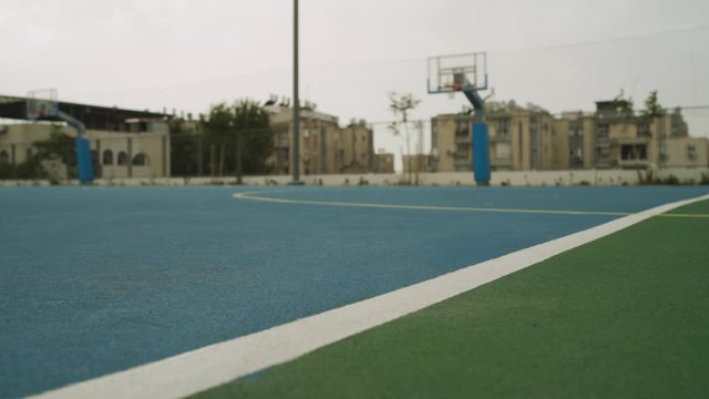 Low angle - local sport courtyard with a basket in background