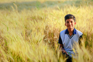 Naklejka na ściany i meble Indian / Asian little boy playing in wheat field