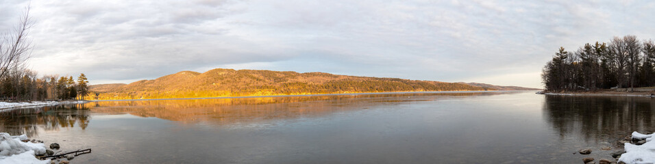Panoramic view of a lake and mountains at winter sunrise