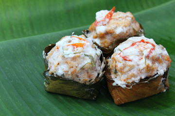 Thai traditional food, steamed fish with curry paste and coconut milk (Hormok) on banana leaf background