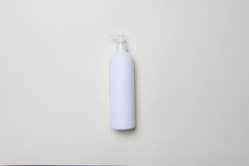 white bottle with detegrent on colored paper background