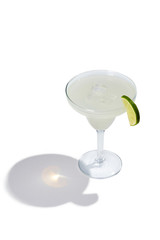 Daiquiri cocktail is contained in a margarita glass with a lime slice on the rim. The showy illustrative picture is made on the white background.