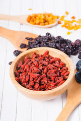 dried goji, cherry, raisin and plum fruits on white wood