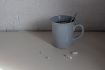 Fototapeta na wymiar Cup and pills on the table. For patients. Quarantine