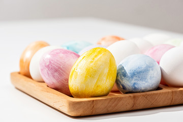  Collection of colorful Easter eggs on a wooden stand. Close-up.