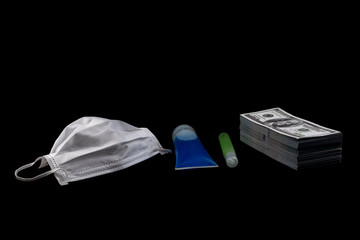 Doctor mask and virus protection alcohol gel bottle and money a stack of 100 US dollars banknote a lot of at the black background, That was It costs expensive price and high priced products concept