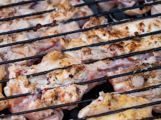 Grilled chicken legs on the flaming barbeque grill.