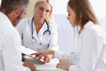 Female family doctor listen carefully young couple in office. Motherhood and child delivery ifv new...