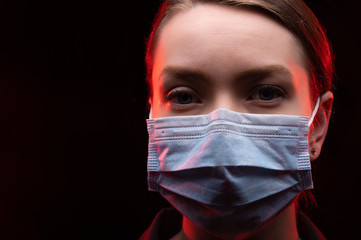 Coronavirus virus in 2020 flu, epidemic. Girl in a protection mask on a black background, Danger of the Chinese virus