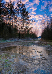 A cold sunset in winter on a frozen lake with a beautiful sky and sunbeams in the background Friesland, The Netherlands