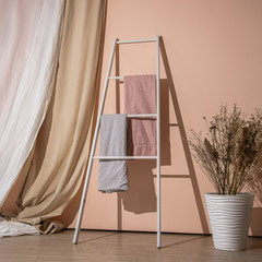 Home interior with ladder with textile, immortelle and curtains