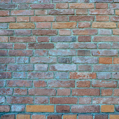 Old brick wall of weathered brick of different colors as a background