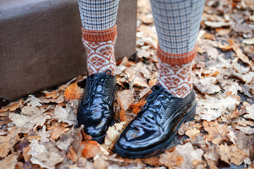 Black patent leather shoes and an old brown suitcase