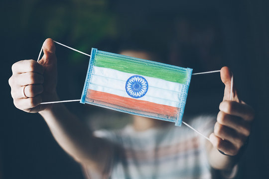 medical mask in hands of man, with the flag of India painted. Copy space